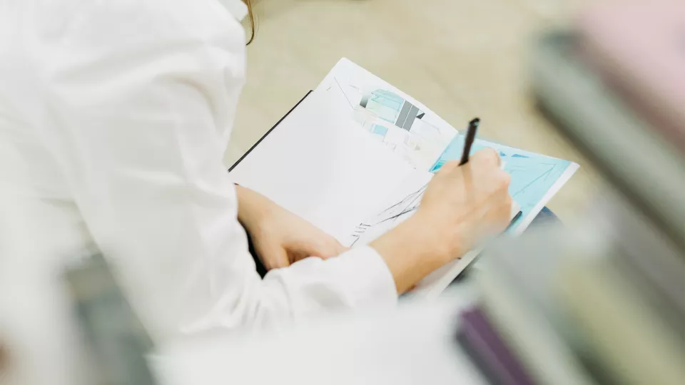 Une étudiante prend des notes pendant un cours théorique du Tronc Commun OrTra TC chez Equilibre Formation.